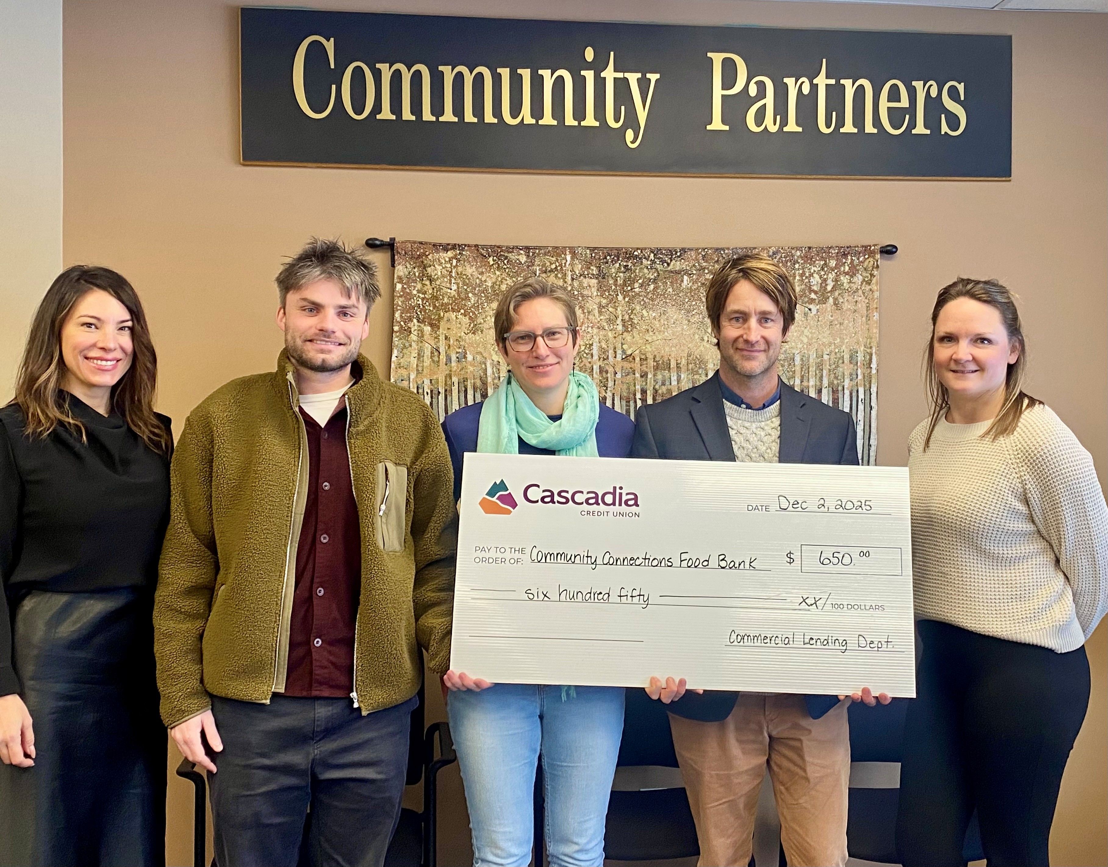 Four adults standing behind an oversize cheque.
